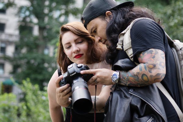 A photographer showing an image on her camera to a customer.