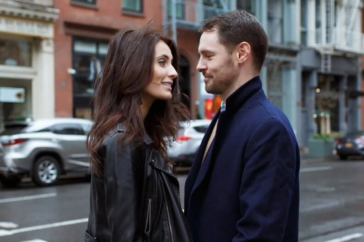 A man and a woman looking at each other affectionately on a city street