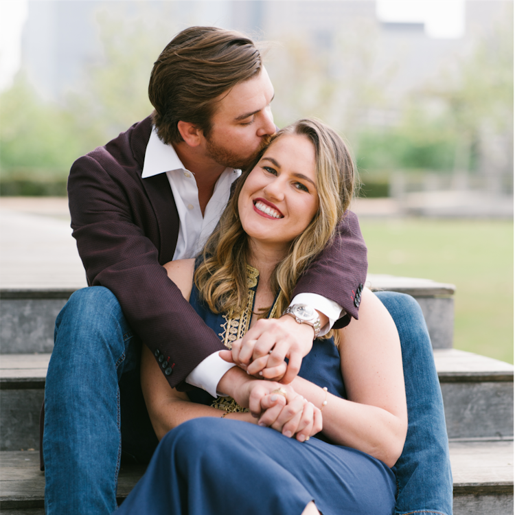 A man kissing a woman on the cheek while sitting on wooden steps.