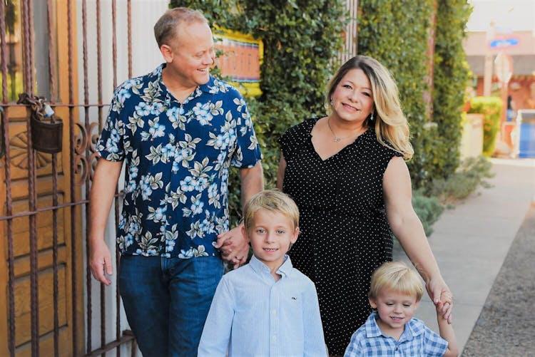 A family of four walking side by side in an urban setting.