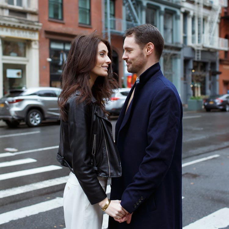 Couple holding hands and gazing at each other on a city street